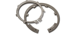 Zwei Metall-Sicherungsringe liegen überlappend auf einer Fläche.